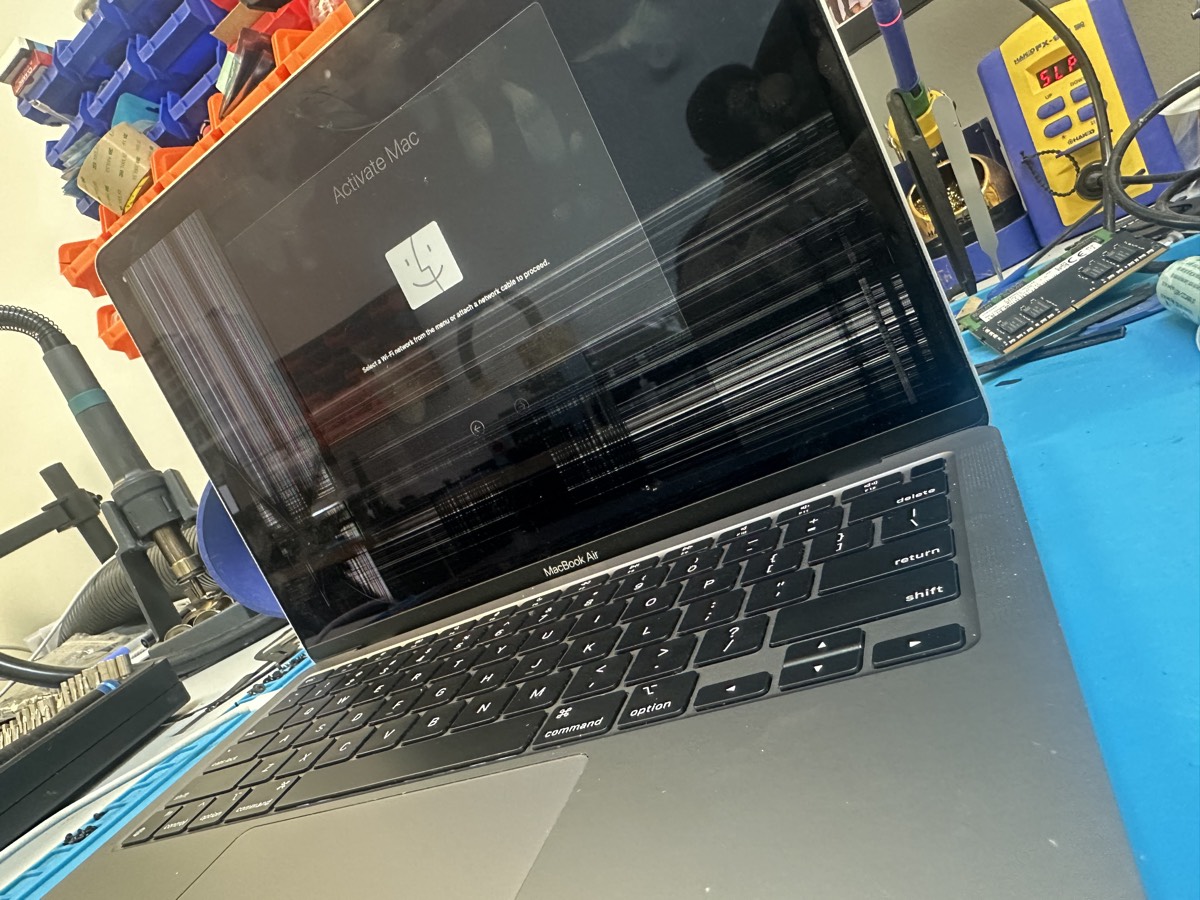 MacBook Air with cracked screen showing horizontal lines at The Mac Space repair shop